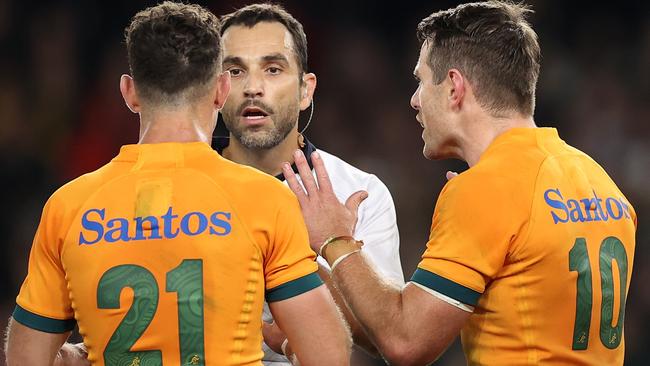 Referee Mathieu Raynal speaks to Nic White and Bernard Foley. Picture: Cameron Spencer/Getty Images