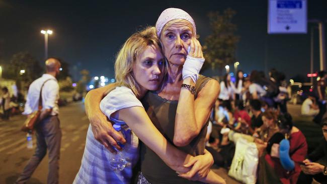 Passengers embrace each other as they wait outside Istanbul's Ataturk Airport early Wednesday. Picture: Emrah Gurel/AP