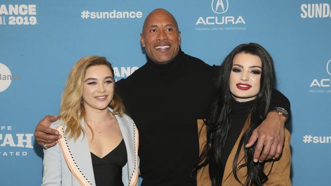 From left to right, cast members Florence Pugh, producer and cast member Dwayne Johnson, and WWE's Paige pose at the premiere of the film Fighting With My Family. (Photo by Danny Moloshok/Invision/AP)