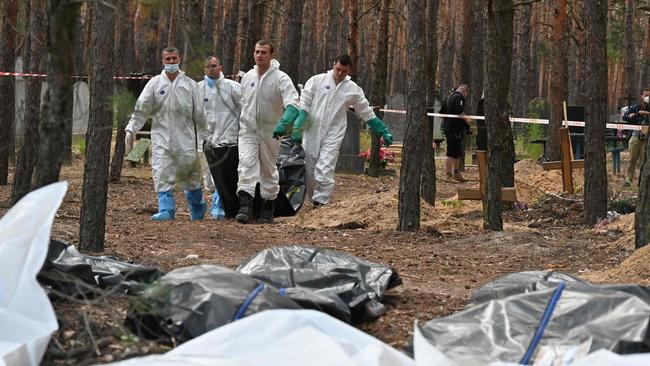 Ukrainian forensics carry body bags in a forest near Izyum, eastern Ukraine, on Monday. Picture: Sergey Bobok / AFP