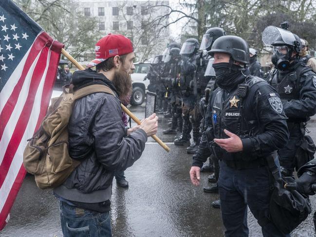 SALEM, OR - JANUARY 06: A supporter of President Trump speaks with riot police during a protest on January 6, 2021 in Salem, Oregon. Trump supporters gathered at state capitals across the country to protest today's ratification of Joe Biden's Electoral College victory over President Trump in the 2020 election.   Nathan Howard/Getty Images/AFP == FOR NEWSPAPERS, INTERNET, TELCOS & TELEVISION USE ONLY ==