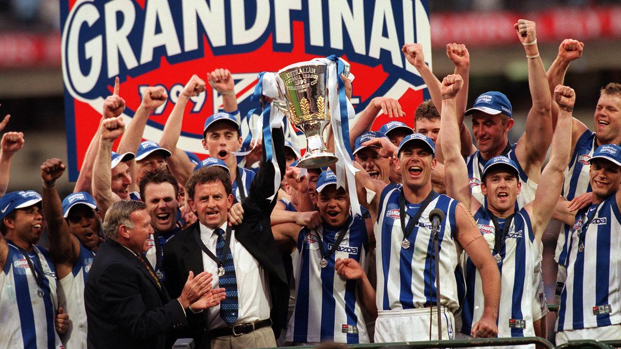 Wayne Carey with coach Denis Pagan and teammates holding up the premiership cup in 1999.