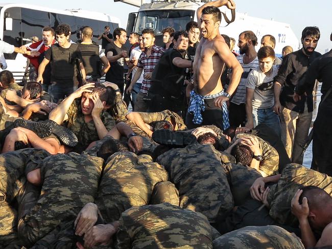 An unidentified man uses his belt to hit Turkish soldiers involved in the coup attempt. Picture: Gokhan Tan/Getty Images