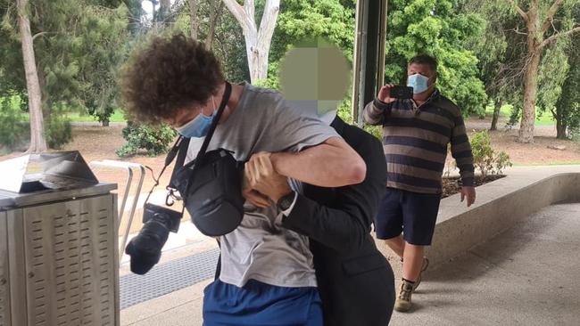 The protester was initially subdued by a plainclothes officer after attempting to gatecrash Premier Steven Marshall's daily Covid press conference. Picture: Andrew Hough