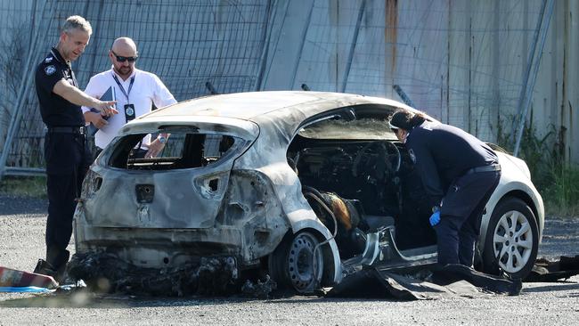 Police at the crime scene where a body was discovered in a burnt-out car. Picture: Liam Kidston