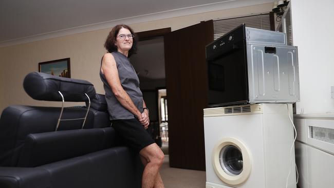 Surry Hills resident Julie Waters has old appliances piling up in her lounge room after council paused collections. Picture: John Grainger