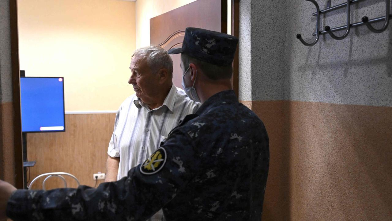 A law enforcement officer stands next to Anatoly Navalny, Alexei’s father, as he watches court hearings via video link in penal colony about 250km east of Moscow. Picture: AFP