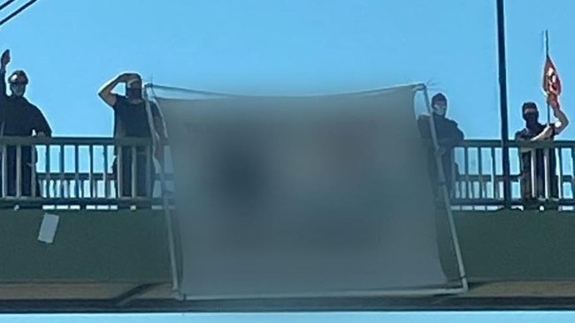 Men flying an offensive banner on the M1 at Helensvale in November last year. Picture: Supplied