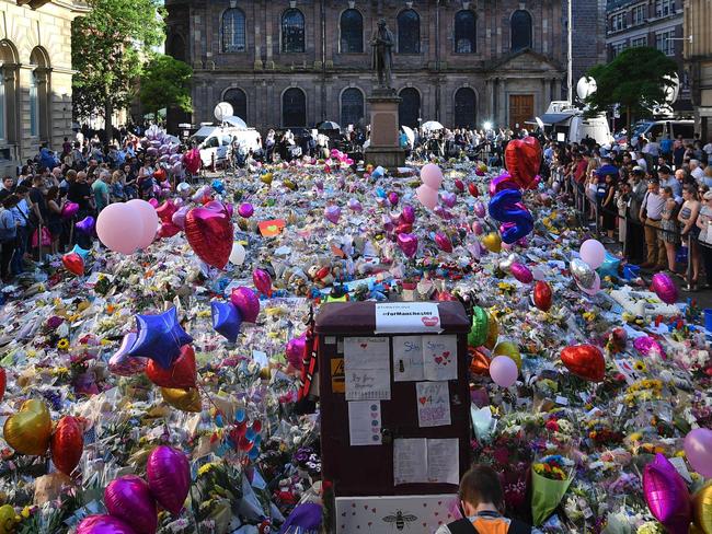 People gather at the flowers and messages of support in St Ann's Square in Manchester. Picture: AFP