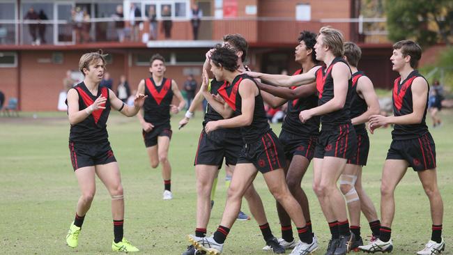 Rostrevor skipper Jayden Gale kicks a goal and is congratulated by his teammates during the eventual win over Scotch in round two. Picture: Emma Brasier