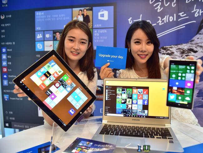 South Korean promotional models present Windows 10, the latest operating system from US software giant Microsoft, during a launch event in Seoul on July 29, 2015. Microsoft is aiming to build lasting relationships with the operating system Windows 10 seen as critical to reviving the fortunes of the once-dominant tech giant. AFP PHOTO / JUNG YEON-JE