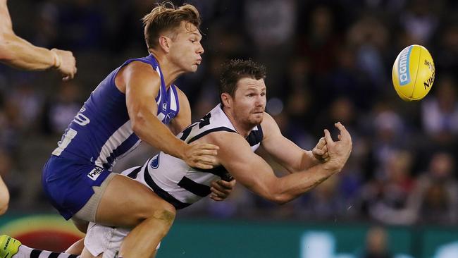 Patrick Dangerfield fires out a handball as Shaun Higgns tackles. Picture: Michael Klein