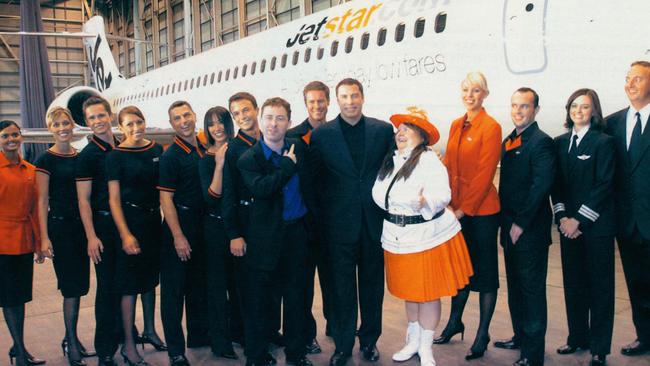 Jetstar staff with then CEO Alan Joyce in the blue shirt with John Travolta and Magda Szubanski. Picture: Supplied