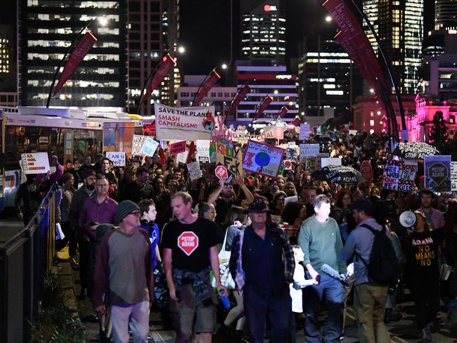 Protesters opposing to the construction of the Adani coal mine march across Victoria Bridge. Picture: Dan Peled/AAP