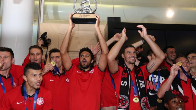 Captain Nikolai Topor-Stanley lifts the trophy as fans cheer at the airport. (Kristi Miller)