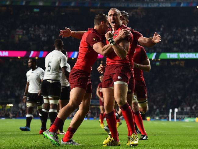 England's fullback Mike Brown (R) celebrates scoring a try during a Pool A match of the 2015 Rugby World Cup between England and Fiji at Twickenham.