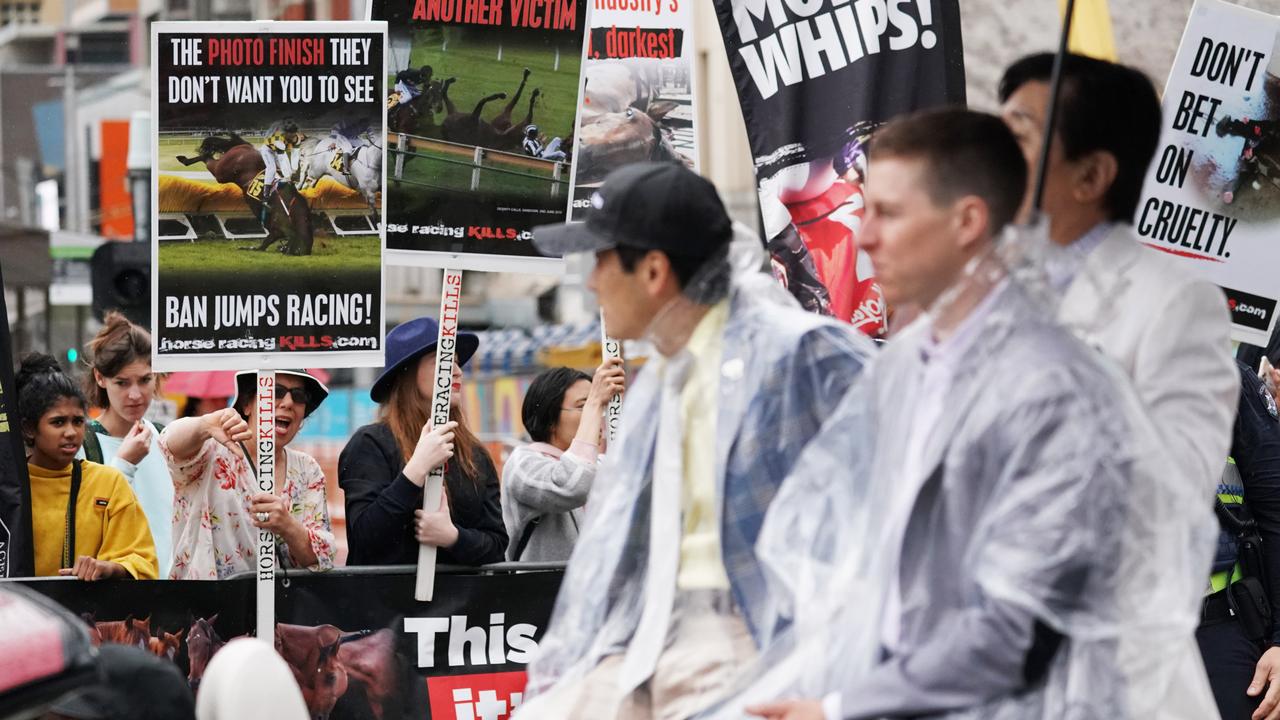 Jockey Damian Lane goes past a protest during the Melbourne Cup parade. Picture: AAP