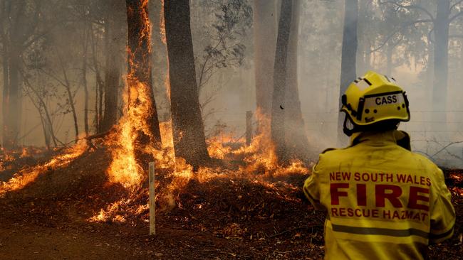 A Gloucester fire crew member fights flames at Koorainghat, near Taree. Picture: AAP