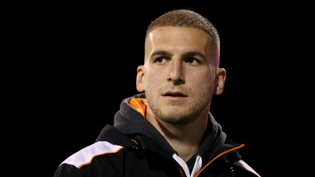 WOLLONGONG, AUSTRALIA - JUNE 07: Injured Wests Tigers player Adam Doueihi looks on ahead of the round 14 NRL match between St George Illawarra Dragons and Wests Tigers at WIN Stadium on June 07, 2024 in Wollongong, Australia. (Photo by Jason McCawley/Getty Images)