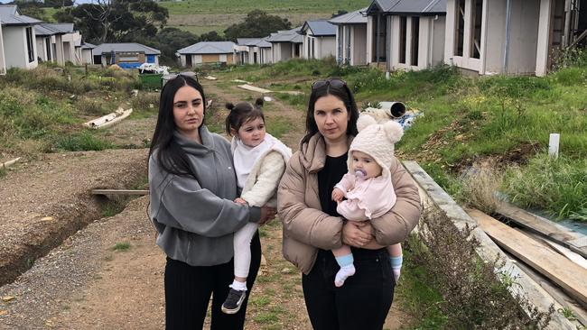 First-time homeowners Devon Craig (L) with her daughter Willow, 2, and Zoe Grzeczkowski (R), 32, with her nine-month-old daughter Elena, have been “left in limbo” with unfinished homes. Picture: Shashi Baltutis