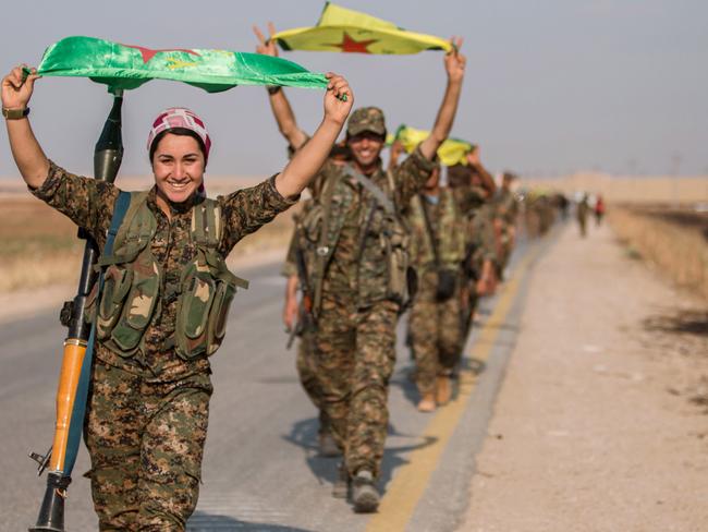 Kurdish fighters gesture while carrying their parties' flags in Tel Abyad of Raqqa governorate after they said they took control of the area June 15, 2015. Syrian Kurdish-led forces said they had captured a town at the Turkish border from Islamic State on Monday, driving it away from the frontier in an advance backed by U.S.-led air strikes that has thrust deep into the jihadists' Syria stronghold. The capture of Tel Abyad by the Kurdish YPG and smaller Syrian rebel groups means the Syrian Kurds effectively control some 400 km (250 miles) of the Syrian-Turkish border that has been a conduit for foreign fighters joining Islamic State. Picture taken June 15, 2015. REUTERS/Rodi Said TPX IMAGES OF THE DAY - RTX1GPFR
