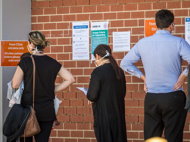 People queue outside a for a fever clinic at Epping Hospital. Picture: Jake Nowakowski