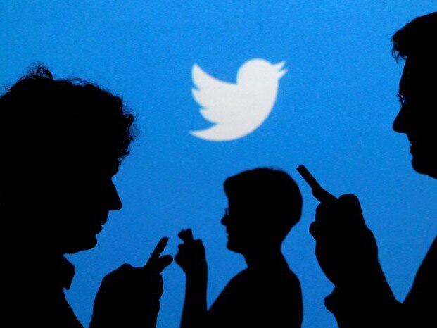 FILE PHOTO -  People holding mobile phones are silhouetted against a backdrop projected with the Twitter logo in this illustration picture taken in  Warsaw September 27, 2013.   REUTERS/Kacper Pempel/File Photo - RC17C7F2F970