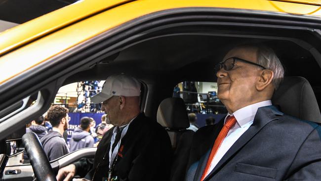 A man poses with statue of Warren Buffetat the Berkshire Hathaway shareholders meeting . Picture: Chandan Khanna/ AFP.