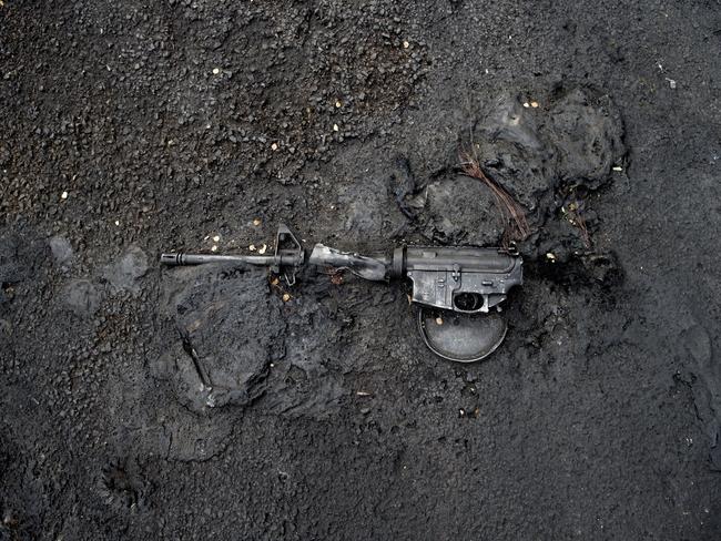 A rifle is melted into the pavement where a police car was also burned outside the downtown library in Salt Lake City.