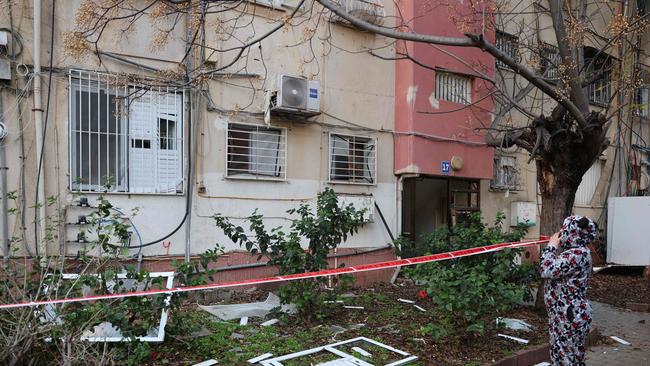 A woman inspects the damage as she evacuates her home in Tel Aviv early on December 21, 2024, after a projectile fired from Yemen landed near her building. Picture: AFP