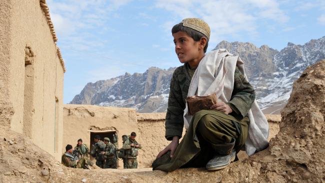 A young Afghan enjoys an ADF ration pack treat at Tarin Kowt Afghanistan.