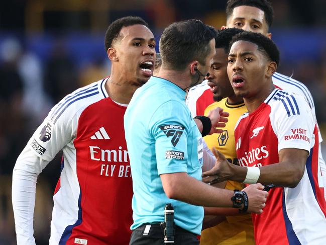 Arsenal's English midfielder #49 Myles Lewis-Skelly (R) reacts after being sent off by English referee Michael Oliver (C) during the English Premier League football match between Wolverhampton Wanderers and Arsenal at the Molineux stadium in Wolverhampton, central England on January 25, 2025. (Photo by Darren Staples / AFP) / RESTRICTED TO EDITORIAL USE. No use with unauthorized audio, video, data, fixture lists, club/league logos or 'live' services. Online in-match use limited to 120 images. An additional 40 images may be used in extra time. No video emulation. Social media in-match use limited to 120 images. An additional 40 images may be used in extra time. No use in betting publications, games or single club/league/player publications. /