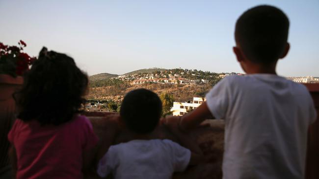 Palestinian children in the Israeli-occupied West Bank look towards a Jewish settlement. Picture: AFP