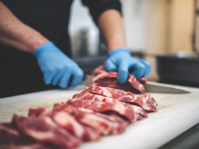 Too much red meat is too much. steak being cut by a butcher