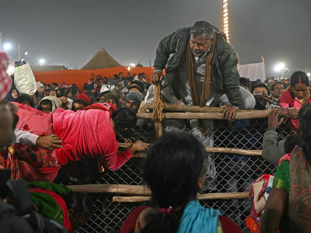 Pilgrims try to cross over a barricade upon their arrival to take a holy dip at Sangam, the confluence of the Ganges, Yamuna and mythical Saraswati rivers, on the occasion of 'Mauni Amavasya' during the Maha Kumbh Mela festival. Picture: AFP