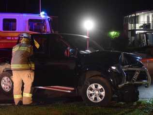 A firefighter inspects a ute after it crashed into a power pole at the intersection of King St and Lavarack Crescent in Buderim.