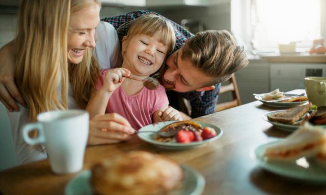 Picture of a young happy family having breakfast together