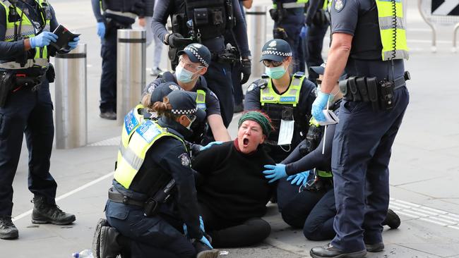 A woman is restrained at Saturday’s anti-lockdown protest. Picture: Alex Coppel.