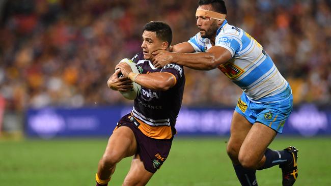 Kodi Nikorima (left) of the Broncos is tackled by Ryan James (right) of the Titans during the Round 4 NRL match at Suncorp Stadium. Photo: AAP