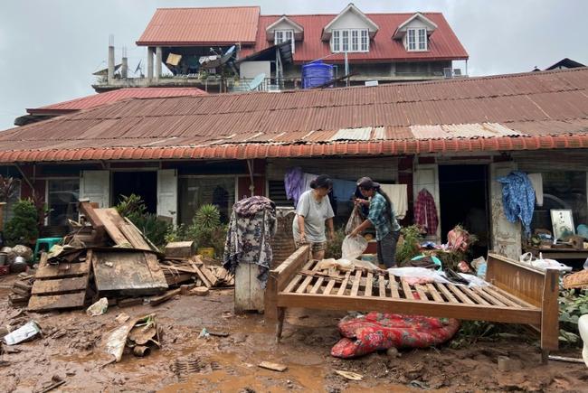 People clean up after major flooding in Kalaw township in Myanmar's southern Shan state on September 19, 2024, following heavy rains in the aftermath of Typhoon Yagi