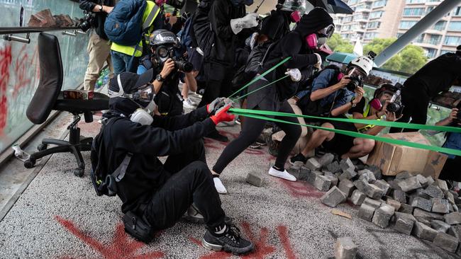 Protesters let rip with bricks in a clash with police at Hong Kong's City University on Tuesday. Picture: AFP