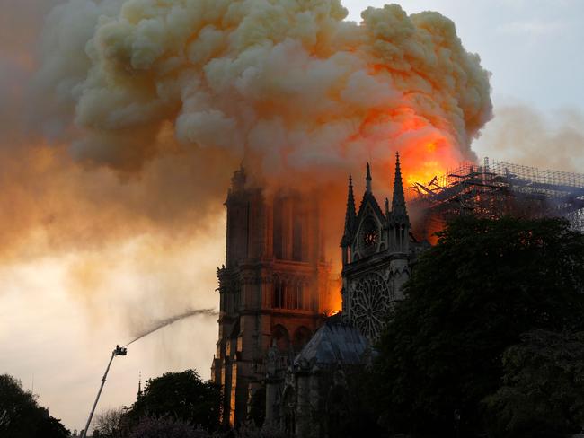 A firefighter uses a hose to douse flames and smoke billowing from the roof at Notre-Dame Cathedral in Paris on April 15, 2019.(Photo by GEOFFROY VAN DER HASSELT / AFP)