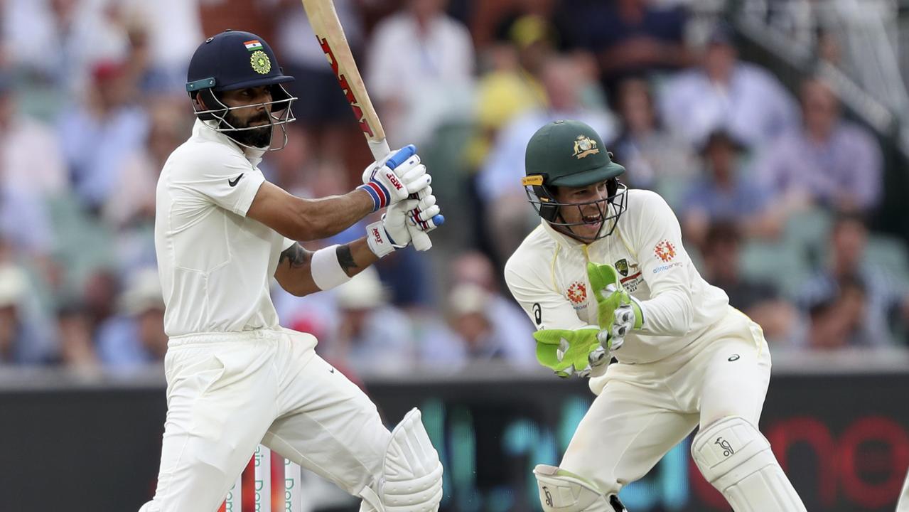 India's Virat Kohli hits the ball in front of Tim Paine.