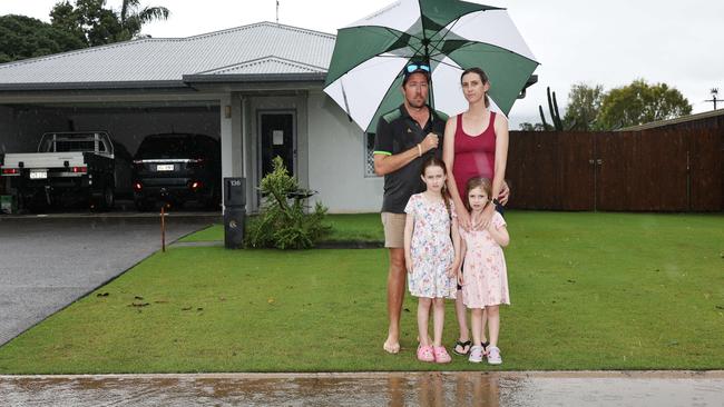 Heavy rain in Gordonvale caused flooding in Campbell Street. Stevie-Lee Hurst and Joshua Hurst, pictured with their daughters Chelsea-Lee Hurst, 5, and Darcie-Lee Hurst, 4, saw the flood water rise through their front yard to their doorstep. Picture: Brendan Radke