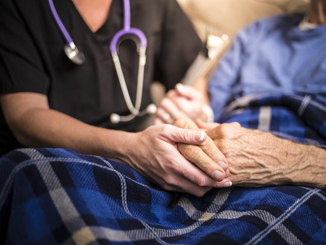 A stock photo of a Hospice Nurse visiting an Elderly male patient who is receiving hospice/palliative care.