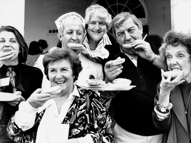 Actor Victoria Nicholls, rugby league legend Johnny Raper, cookbook writer Margaret Fulton, swimming legend Dawn Fraser, actors Norm Erskine and Pat McDonald, tuck into Sargents pies at Bondi Surf Lifesaving Club in 1989.