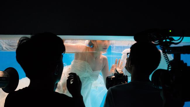 A bride has her wedding photos shot underwater.