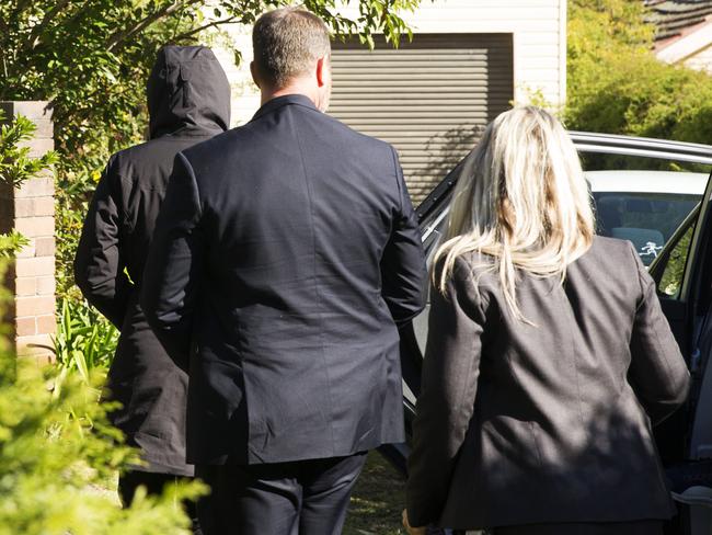 Family and friends are led in the house by detectives today. Picture: Jenny Evans