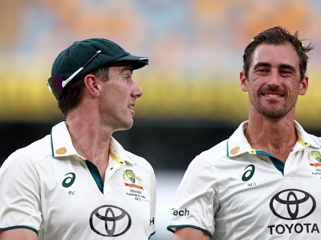 Australiaâs captain Pat Cummins (L) talks with Mitchell Starc as they walk off the ground due to a rain delay on day five of the third cricket Test match between Australia and India at The Gabba in Brisbane on December 18, 2024. (Photo by DAVID GRAY / AFP) / -- IMAGE RESTRICTED TO EDITORIAL USE - STRICTLY NO COMMERCIAL USE --