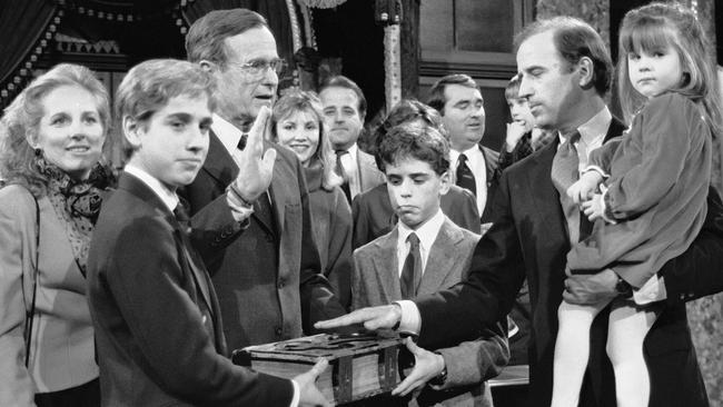 In this 1985 file photo, Sen. Joe Biden holds his daughter, Ashley, while taking a re-enacted oath of office from Vice President George Bush as his sons Beau, foreground, and Hunter hold the bible. Picture: AP Photo/Lana Harris.